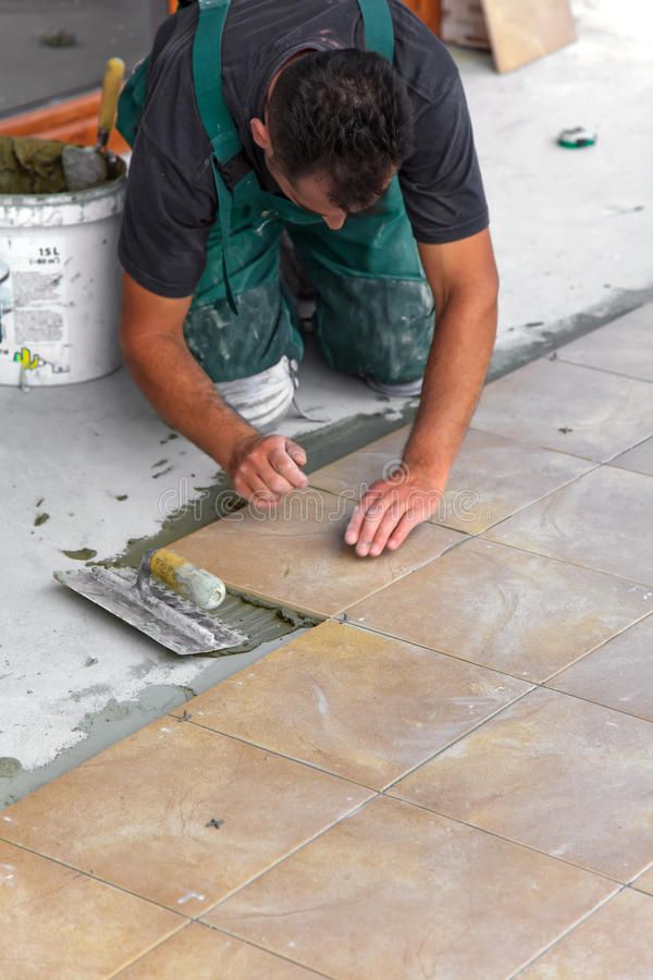Floor tiles installation_ A construction worker…
